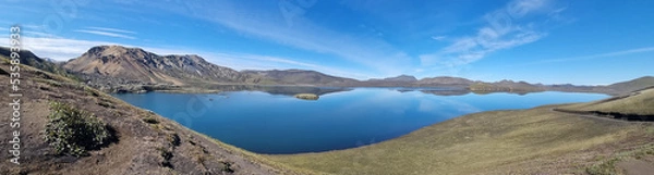 Obraz A beautiful landscape in Iceland of mountains, a bright blue and blue sky of light clouds, reflected in a huge flat surface of reservoir.
