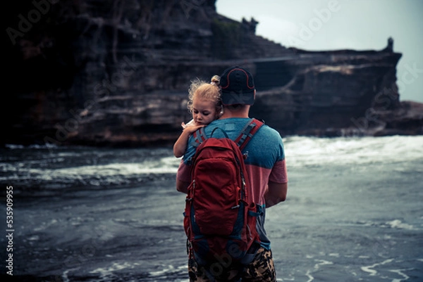 Fototapeta Father hugging his small daughter and looking with hope into the distance 