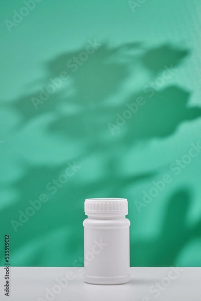 Obraz cosmetic product in tube, glass bottle, lotion, anti-aging moisturizer, facial essential oil or serum on green background with light shadow nature. Organic natural and Beauty skincare concept.