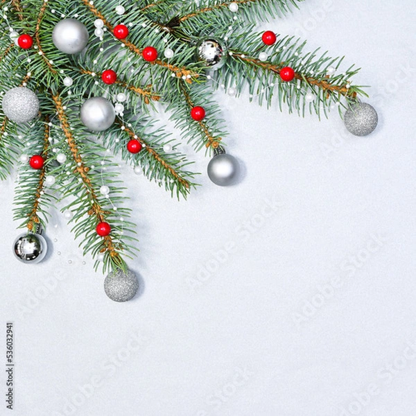 Fototapeta White copy space background with Chrismtas garland with red berries and silver ornaments. FLat lay