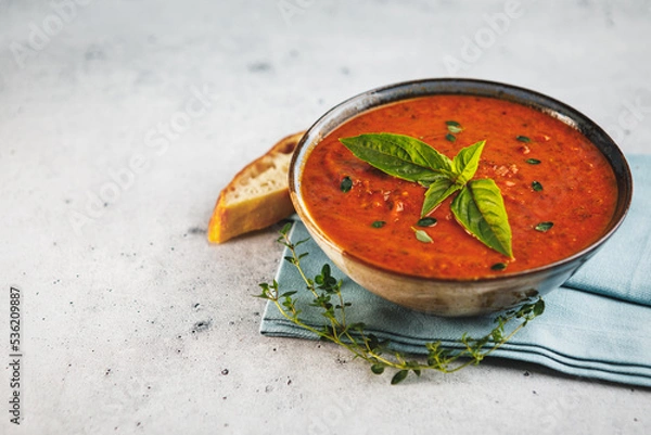 Obraz Bowl of fresh homemade tomato basil soup with fresh herbs and slice of focaccia bread with space for text