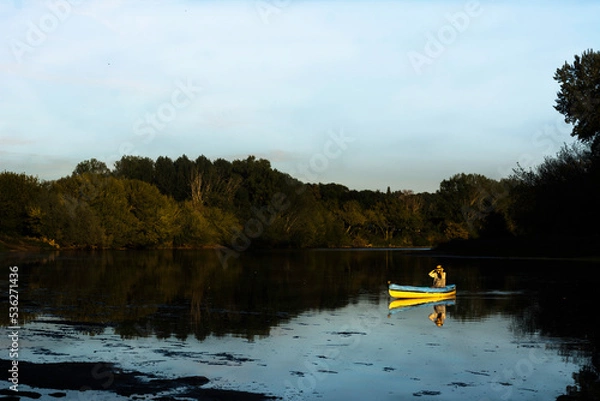 Fototapeta woman kayaking in a boat in a calm river. Beautiful lanscape. Concept of relaxation, wellbeing, tranquility, enjoyment in nature. 