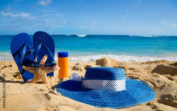 Obraz Flip flops, sunscreen, hat and starfish on sandy beach
