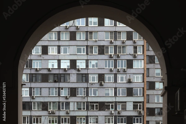 Fototapeta View through the arch at the facade of the building.