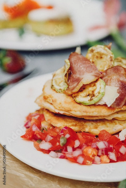 Fototapeta A stack of delicious pancakes with bacon, honey, nuts and caramelized banana. A hearty breakfast.