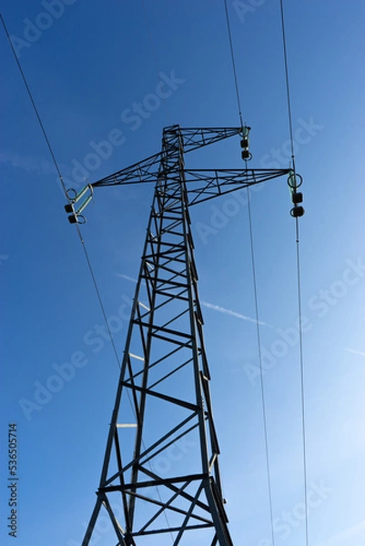 Obraz Electrical high voltage pylon with blue sky in background.