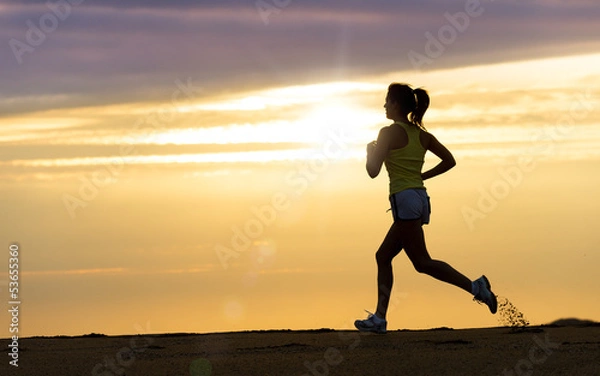 Obraz Athlete running at sunset on beach
