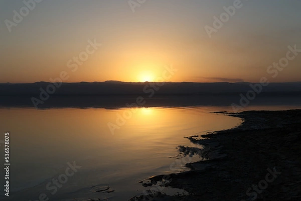 Fototapeta landscape view of coastline of dead sea at sunset
