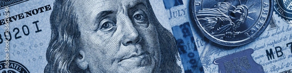 Fototapeta American money close-up. 100 dollar note and 1 dollar coin. Benjamin Franklin and Statue of Liberty. Blue tinted banner or header about US economy. Public debt and USA dollars. Reserve currency. Macro