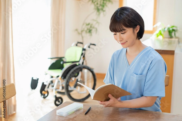 Fototapeta 日誌を書く女性医療従事者