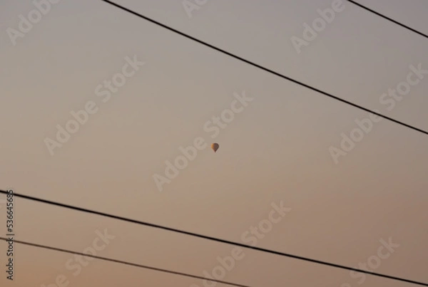 Fototapeta A hot air ballon between power chords 