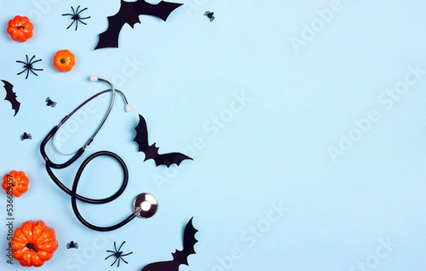 Obraz Stethoscope and Halloween decorations on blue background with copy space.