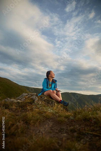 Fototapeta Female tourist sitting and enjoy view of Mountain range. Carpathian Mountain, Ukraine. Walking and hiking trails in Borzhava ridge. Rural area of carpathian mountains in autumn