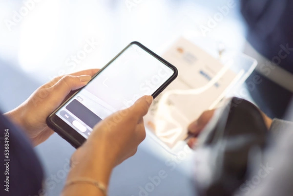 Fototapeta Conference Staff Member scan a QR code from attendee upon arrival to check-in site