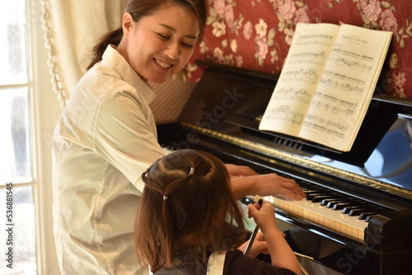 Obraz トライアングルを持ってお母さんと楽器遊びをする女の子