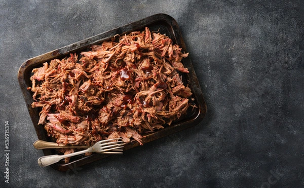 Obraz Traditional barbecue pulled pork. Slow cooked pulled pork shoulder. Juicy pork meat cooked in a smoker by low and slow