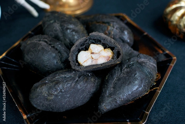 Fototapeta Black meat pie. Dishes for Halloween. Kibinai, kybyn, or kibin- a meat pie, a national dish of the Lithuanian Karaites. Sliced bun. Visible chicken filling