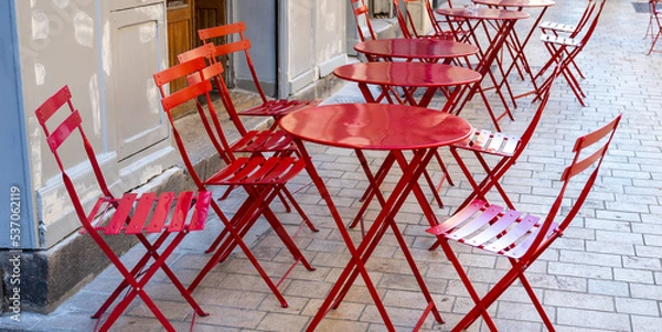 Obraz red tables with chairs of a street cafe