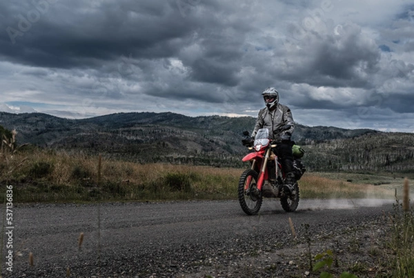 Fototapeta Dual Sport motorcyclist riding on the Continental Divide Ride in Colorado at dusk.