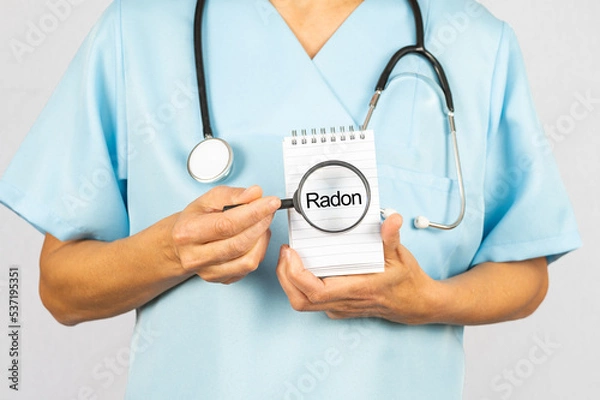 Fototapeta Ärztin oder Krankenschwester mit einer Lupe die das Schlagwort Radon zeigt