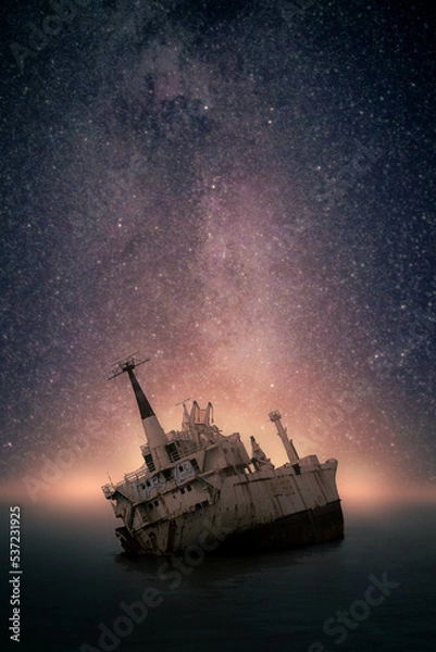 Obraz Stranded old shipwreck on the open ocean with the milky way in the background at dawn
