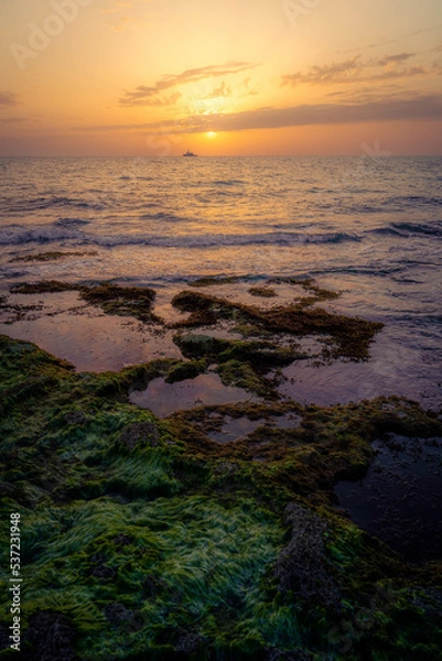 Obraz Boat in the distance during a warm summer sunset at the coast of Cyprus