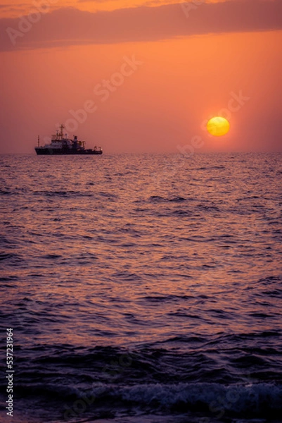 Obraz Boat in the distance during a warm summer sunset at the coast of Cyprus