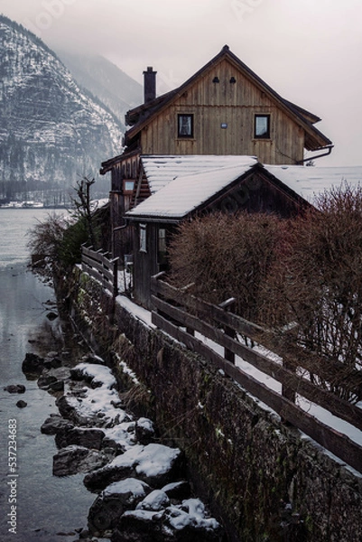 Obraz Typical alpine style buildings in Hallstatt, Austria during a snowy winter afternoon.