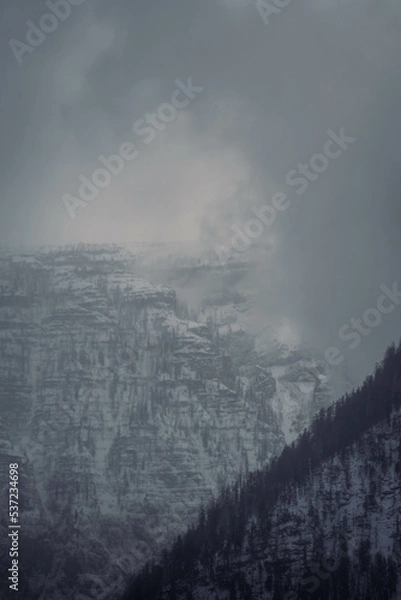 Obraz Mountain range with strong atmosphere during a snowy, dark winter afternoon