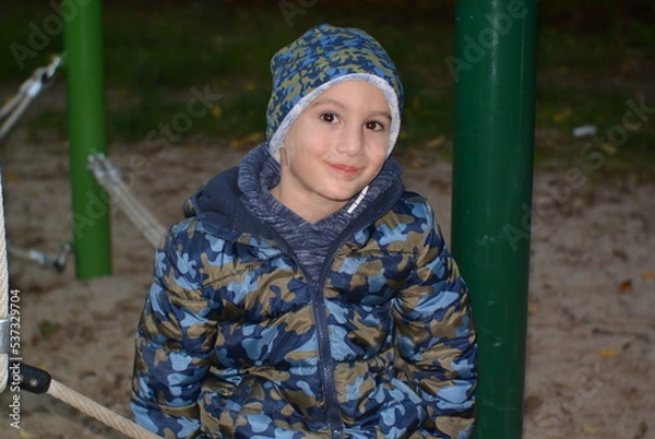 Fototapeta child on a playground in the evening 