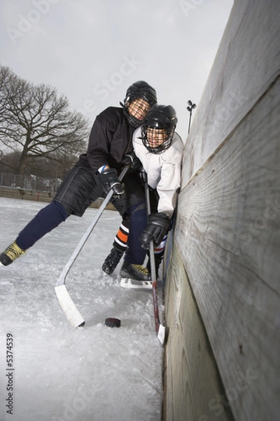 Obraz Ice hockey player boy slamming other player into wall.