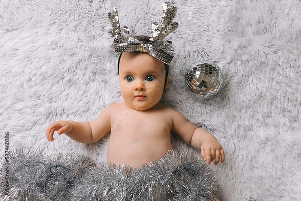 Obraz Baby with Christmas decoration lying on white background. New year and Christmas concept