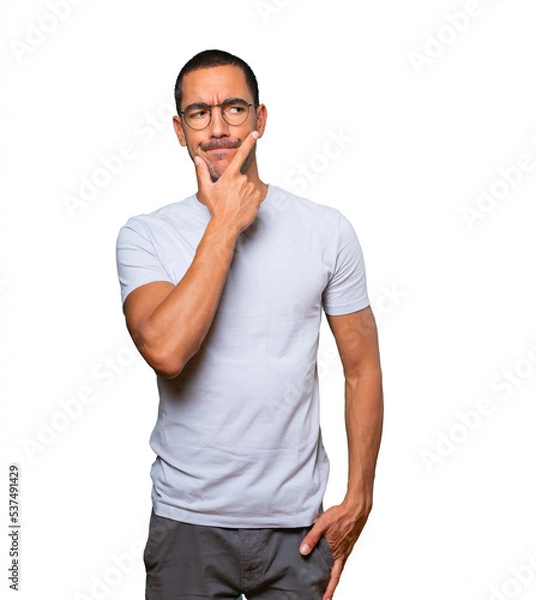 Fototapeta Concerned young man making a gesture of doubt