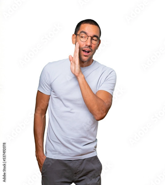 Obraz Confident young man telling a secret