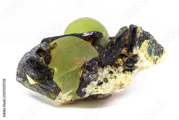 Fototapeta Chunk of real green prehnite spheres and dark green almost black epidote spikes on matrix macro isolated on white surface 