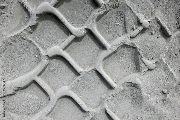 Fototapeta Trace of a car or tractor tire track in the dust sand. Abstract illustration photo of transportation or hard weather traffic conditions.