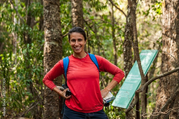 Obraz caucasian woman with red shirt and blue backpack in the jungle of "Calilehua" national park in Jujuy province, Argentina