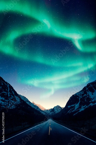 Fototapeta Northern lights aka aurora borealis above a road and mountains in Norway