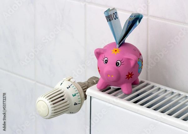 Fototapeta Piggy bank with radiator thermostat saving heating costs