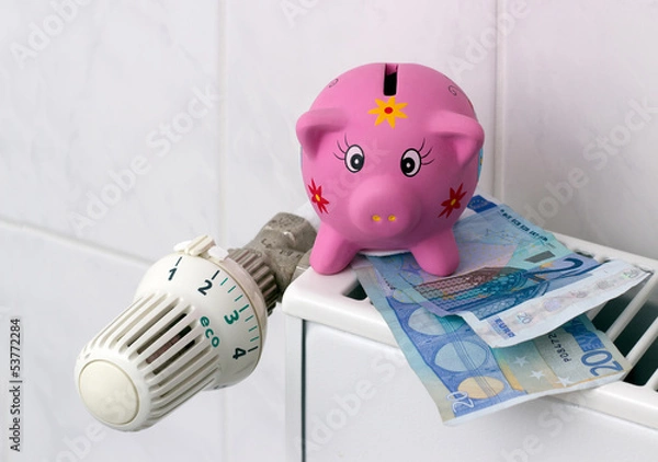 Obraz Piggy bank with radiator thermostat saving heating costs