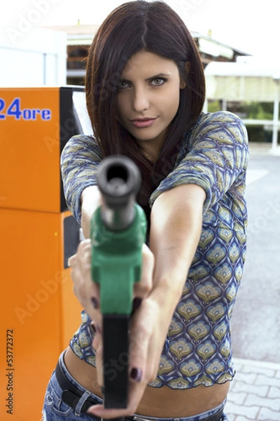 Obraz Portrait of female model holding and pointing gas gun