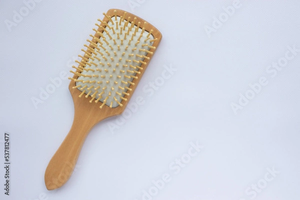 Fototapeta Wooden comb on white background. Modern paddle hair brush on table. Top view, flat lay, copy space. 