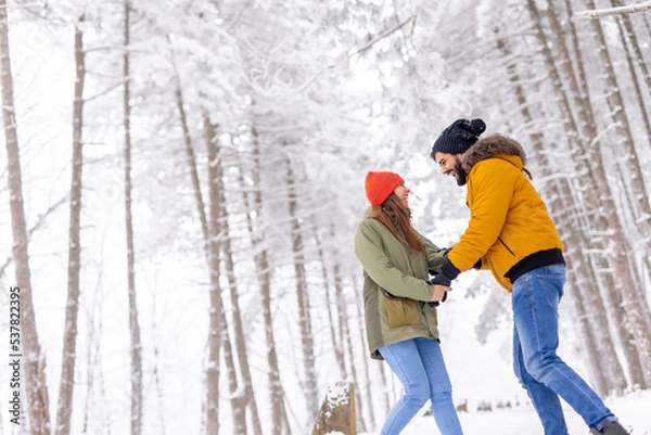 Obraz Couple spending snowy winter day outdoors while on winter vacation