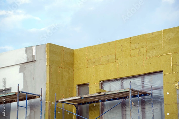 Fototapeta view of construction worker in doing insulation of wall at construction site