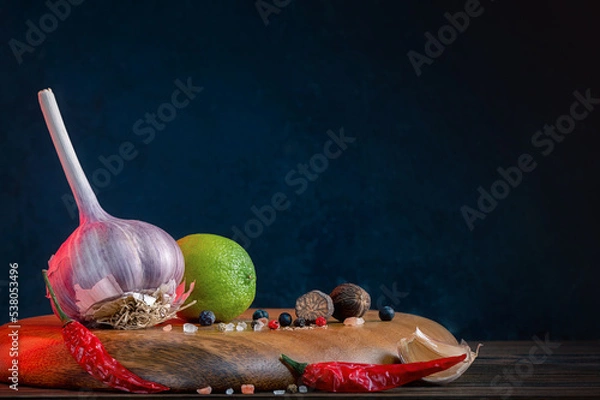 Obraz Whole Bulb Garlic, Lime, And Spices: Chili, Juniper Berries, Black, White And Pink Pepper On A Wooden Board. Kitchen Still Life. Condiments And Traditional Medicine. Dark Background. Place For Text.