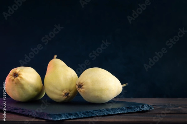 Obraz Three Whole Pears Lie On A Slate Board. Healthy Food. Eco-Friendly Products. Selective Focus. Side View. Dark Background.