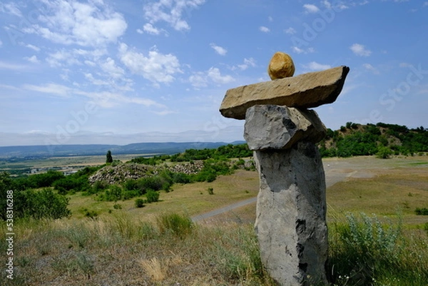 Fototapeta monolithic rock statues with hills in background