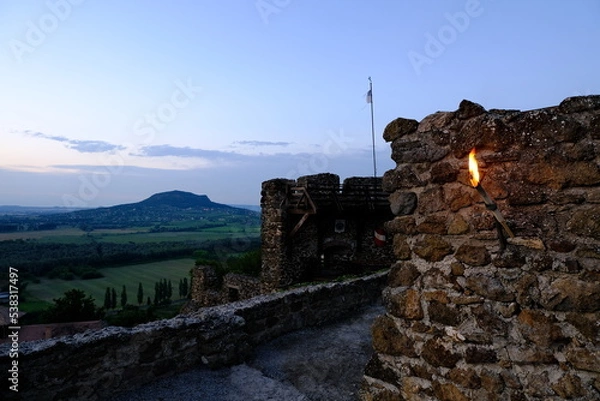 Fototapeta castle on the hill with torch at dusk