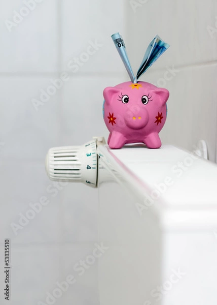 Obraz Piggy bank with radiator thermostat saving heating costs