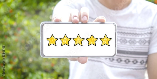 Fototapeta Five star cartoon sketch style on screen smartphone with blurred background. Service rating, satisfaction concept. reviews and comment google maps. online feedback